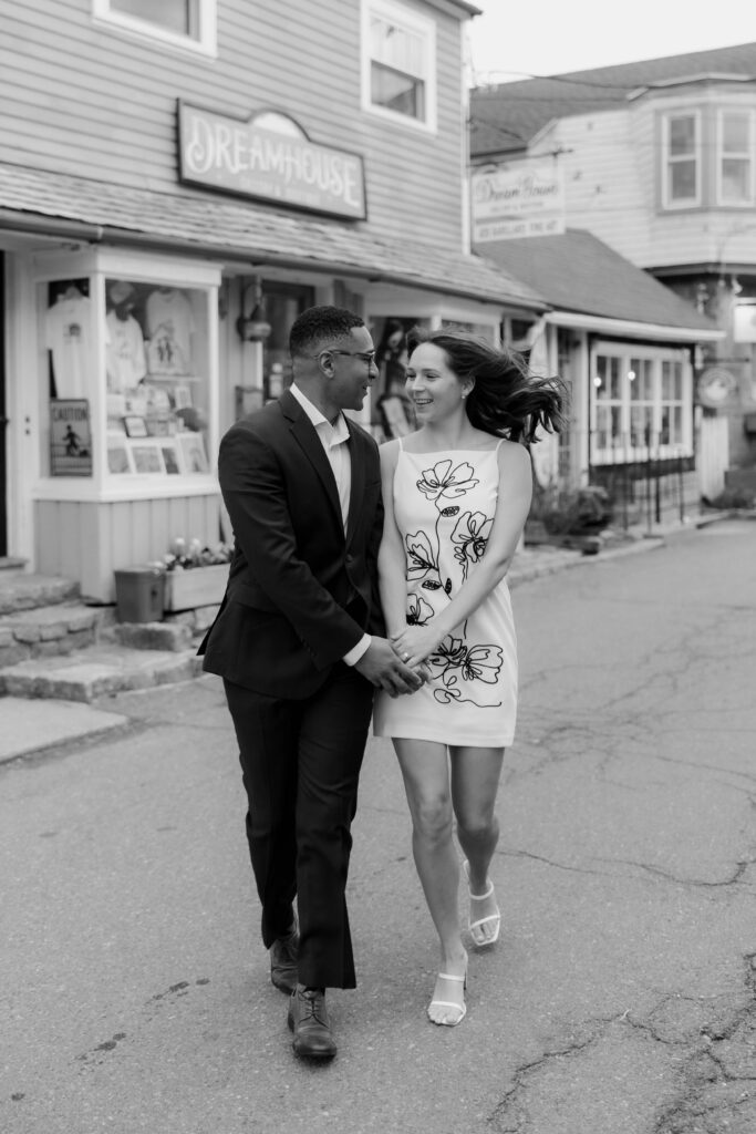 Black and white photo of couple walking through downtown Rockport holding hands