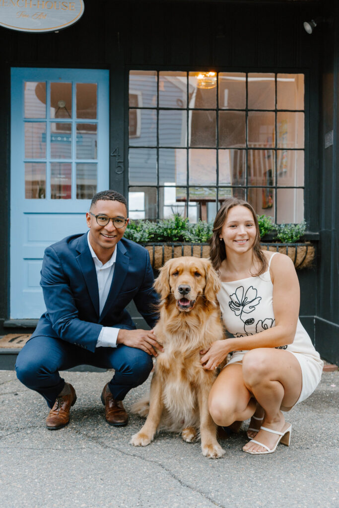 Couple posing with golden retriever dog outside home in Rockport