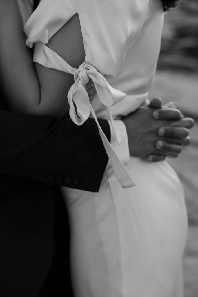 man holding woman's waist in black and white