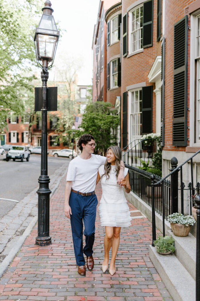 Couple walking together through Beacon Hill Boston during golden hour engagement session