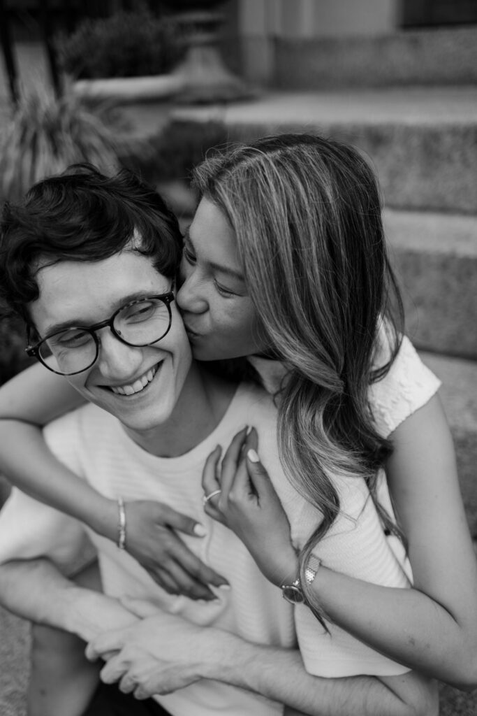 Black and white close up engagement photo of Margaret kissing Chris on the cheek in Boston