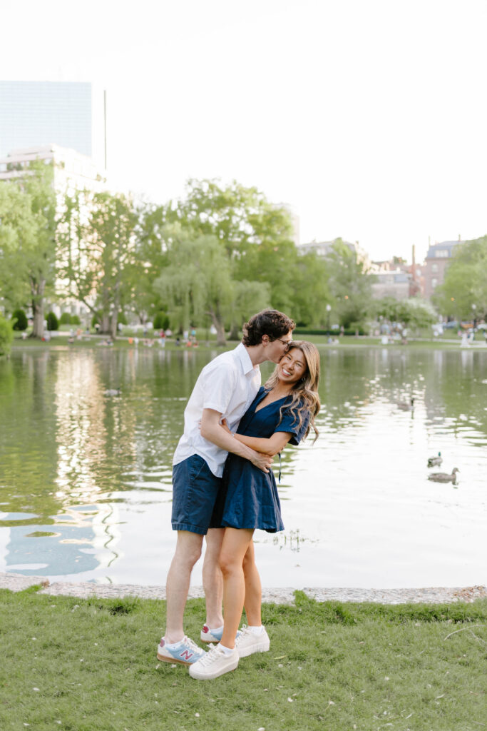 Couple embracing beside the pond in Boston Common during engagement session