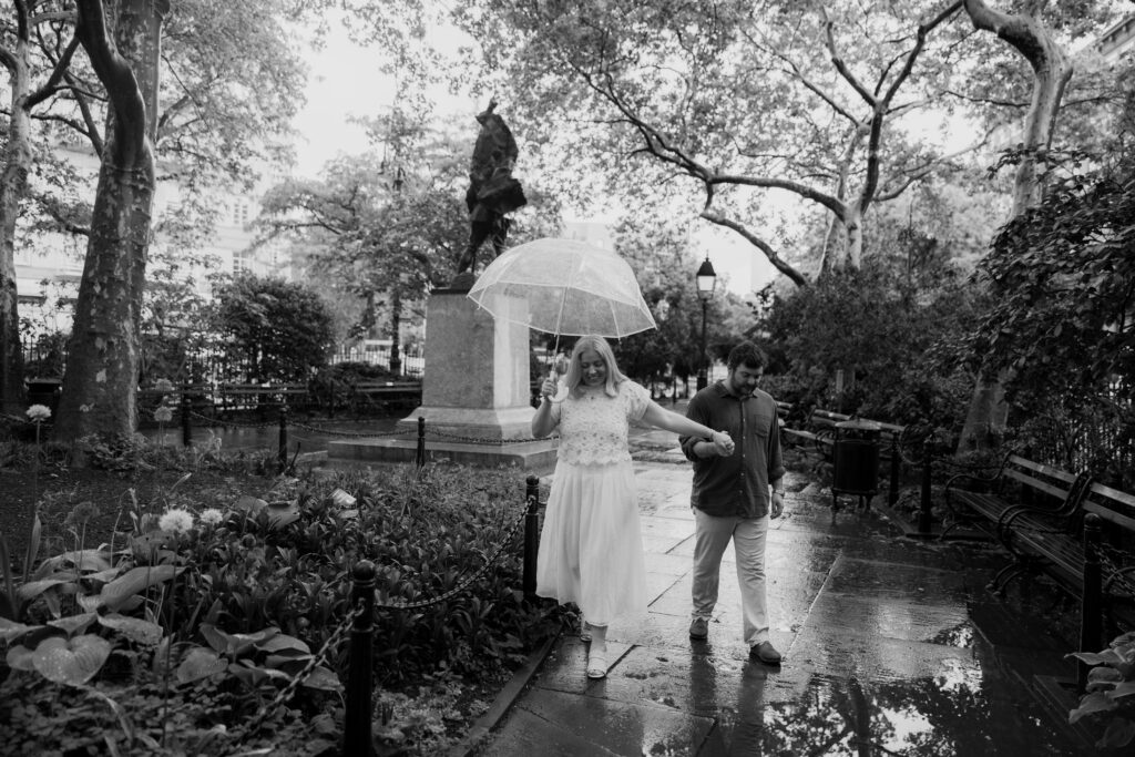 Black and white engagement portraits walking through West Village park in New York City. Photo by Clay Taylor Photo