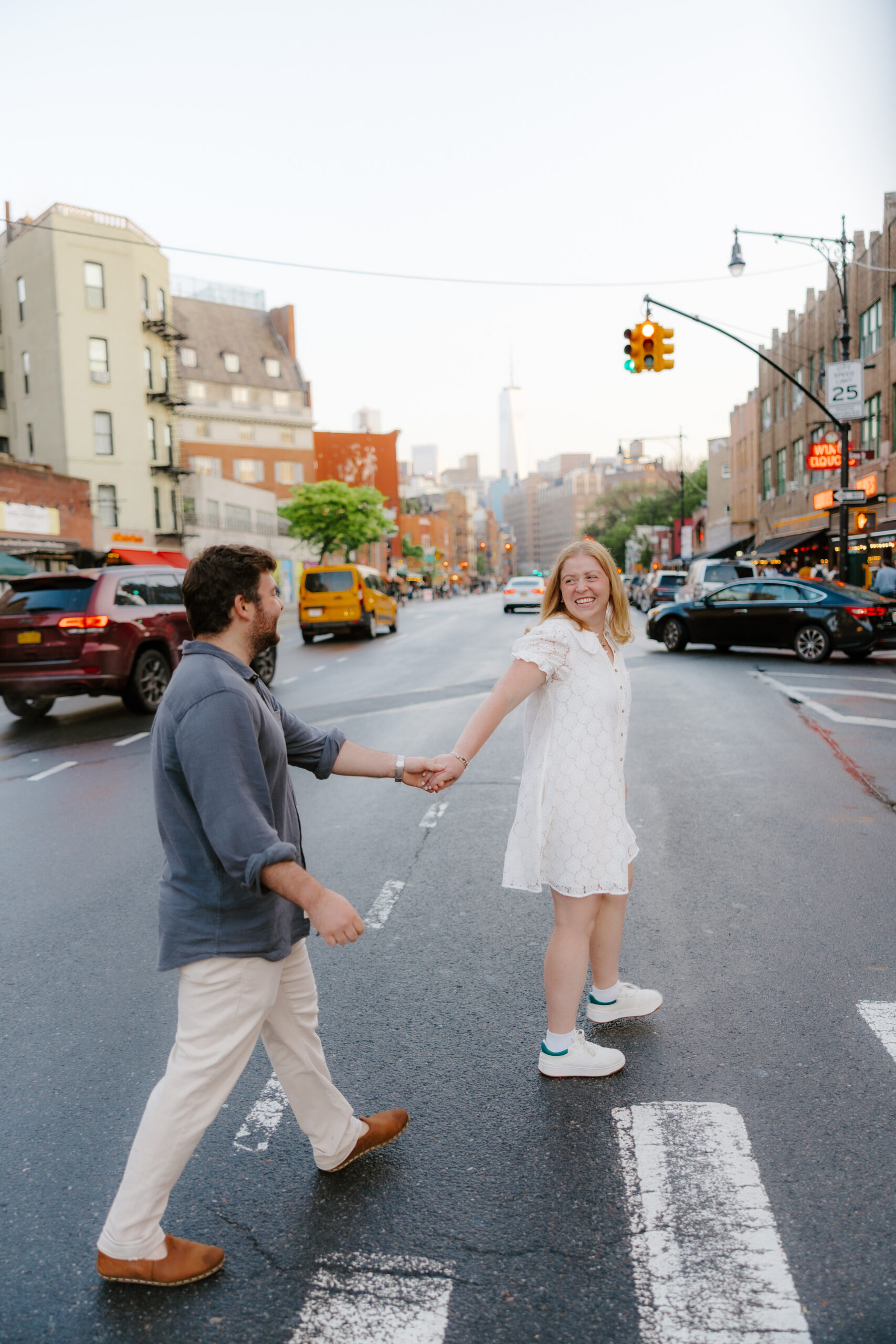 Couple crossing a New York City street during golden hour engagement session in Manhattan. Photo by Clay Taylor Photo