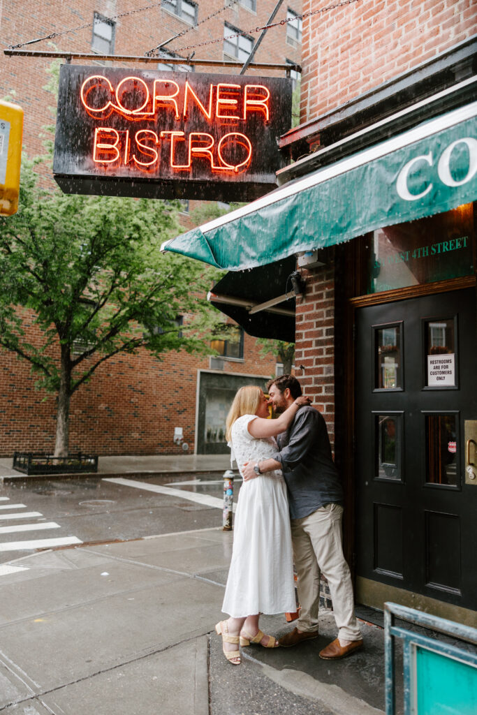 Engagement photos outside Corner Bistro in the West Village during rainy NYC engagement session. Photo by Clay Taylor Photo