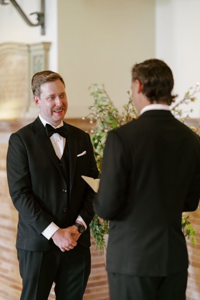 Emotional portrait of Ryan smiling while listening to vows during his Boston Public Library wedding ceremony.