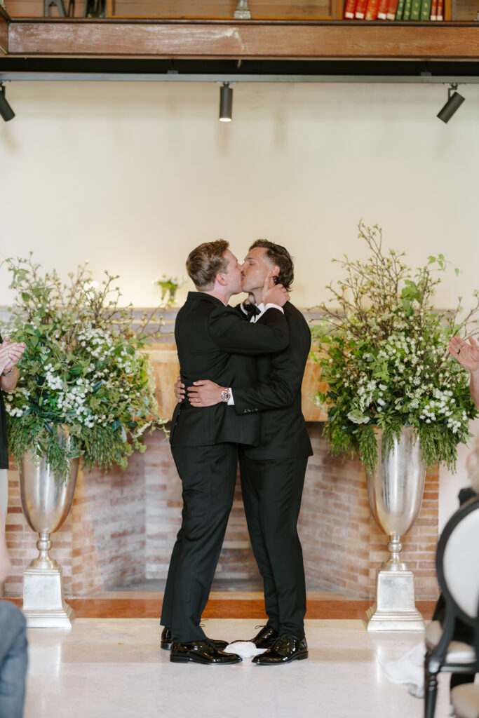 Ryan and Spencer sharing their first kiss after exchanging vows at the Boston Public Library wedding ceremony.