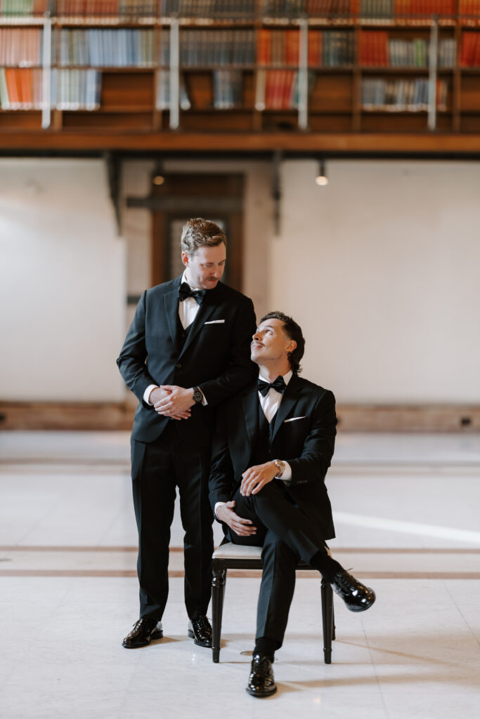 Ryan standing beside Spencer during elegant wedding portraits inside the Boston Public Library in Boston.