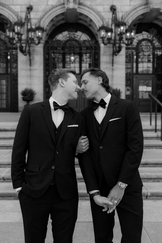 Black and white portrait of Ryan and Spencer sharing an intimate moment outside the Boston Public Library.