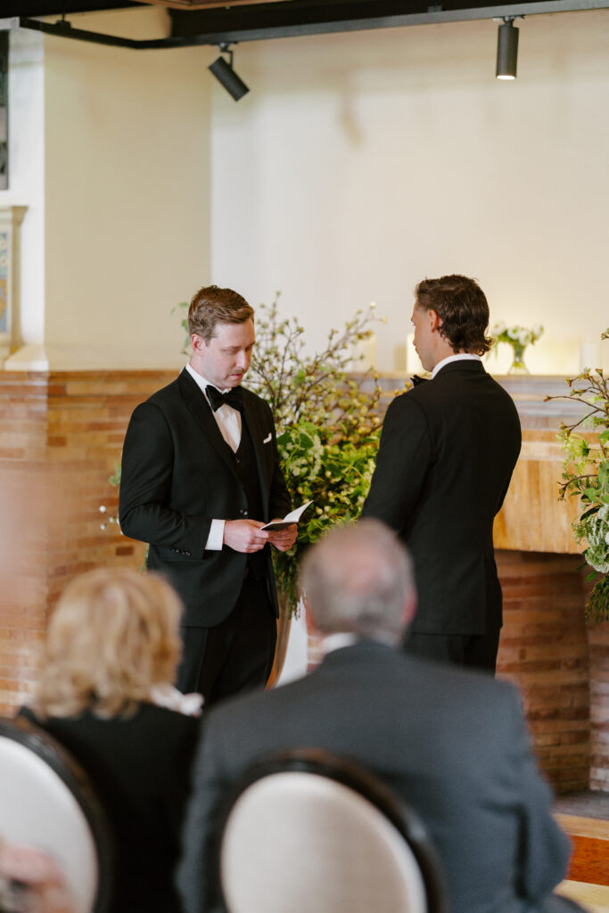 Ryan reading vows to Spencer during an intimate Boston Public Library wedding ceremony in Boston.