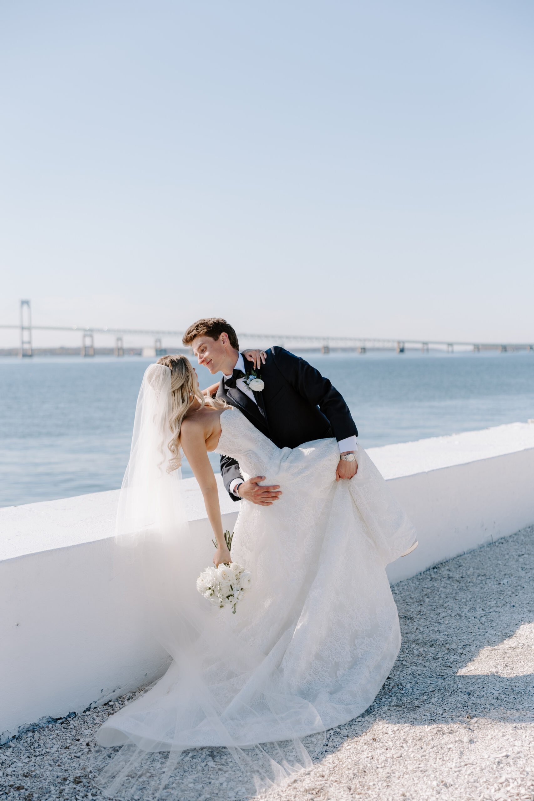 Husband dips bride at Belle Mer with the Claiborne Pell Newport Bridge in the background