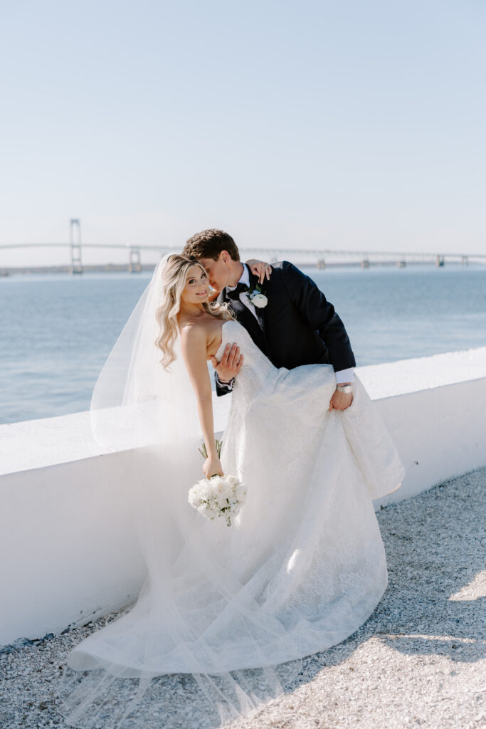 Groom kisses bride on cheek at Belle Mer