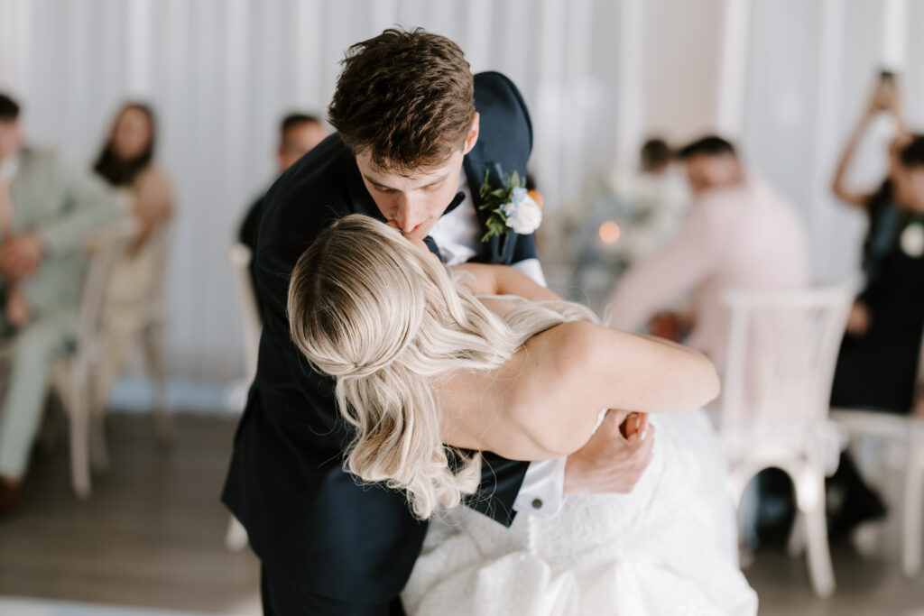 Groom dips bride during first dance at Belle Mer.