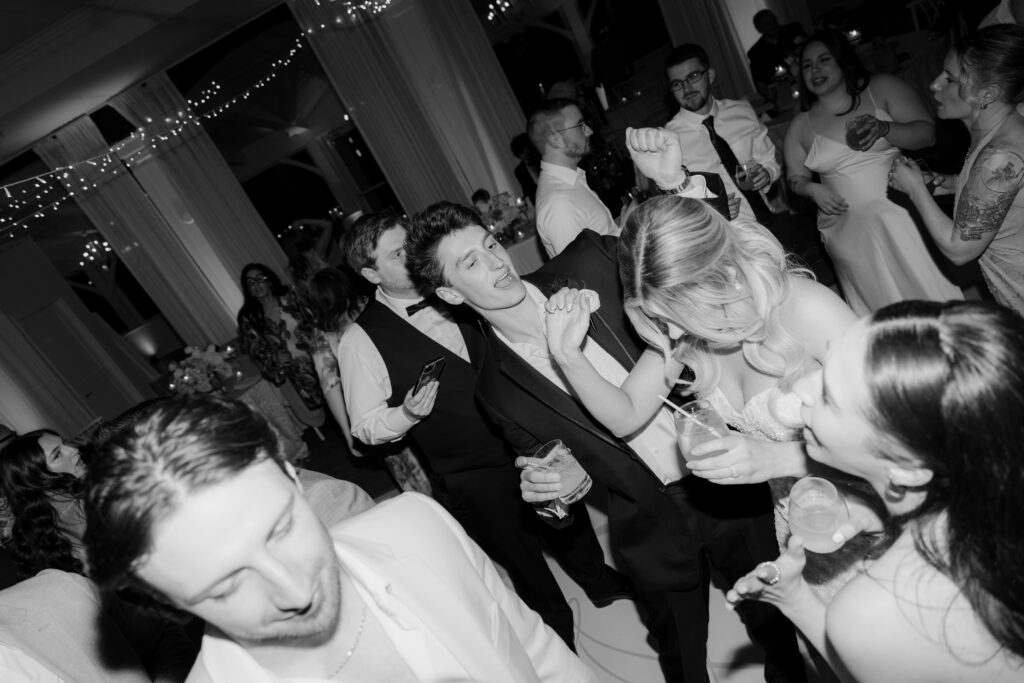 Black and white photo of bride and groom dancing at wedding reception