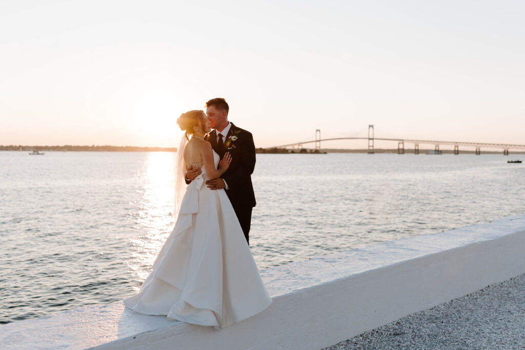 Bride and groom share kiss during sunset portraits in Newport, Rhode Island