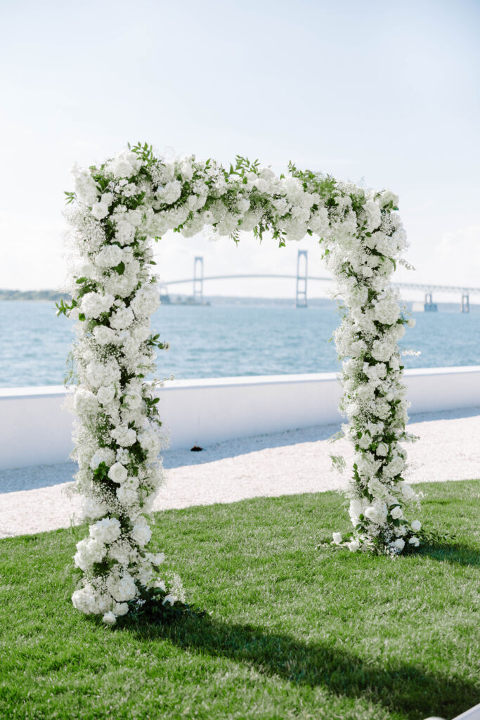 Ceremony arbor with beautiful green and white floral at Belle Mer, Newport, Rhode Island