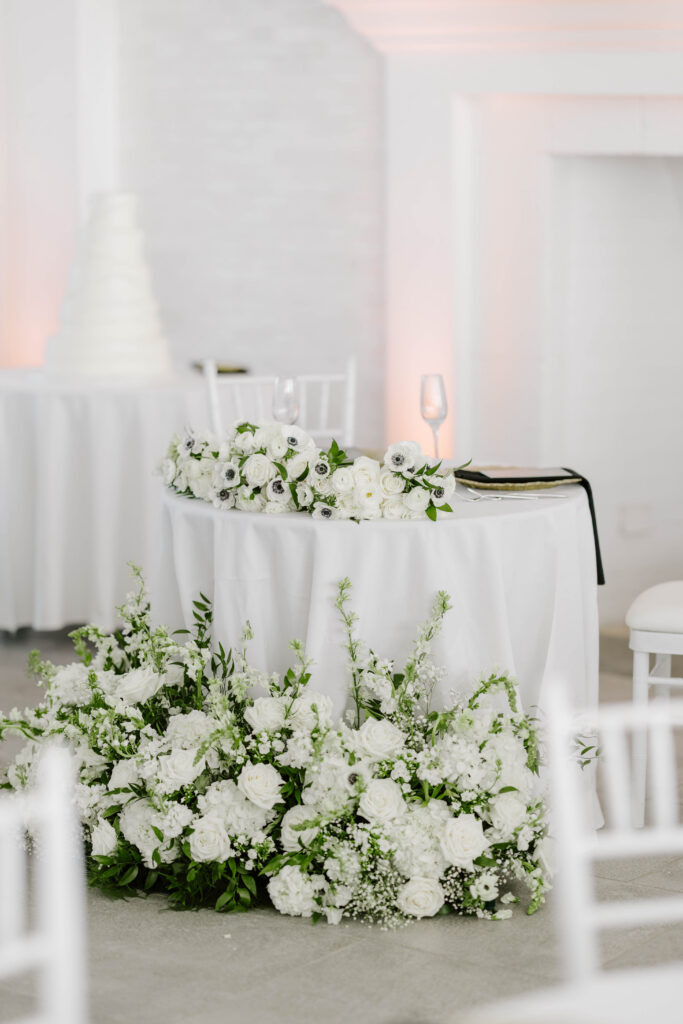 Sweetheart table detail photo with green and white floral surrounding table