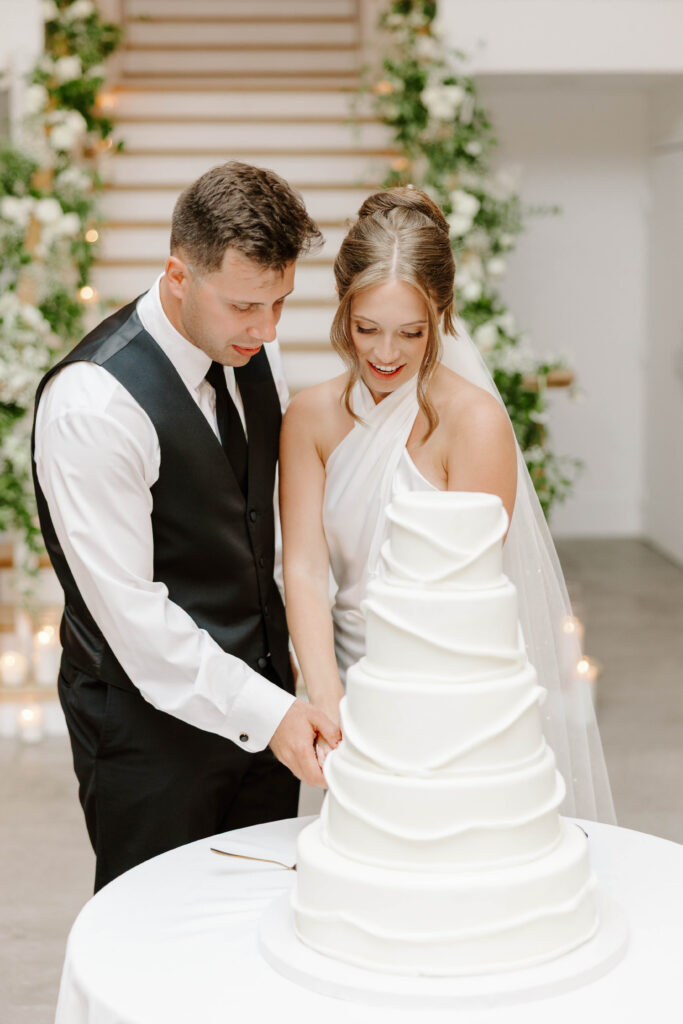 Bride and groom cut cake at Newport wedding reception