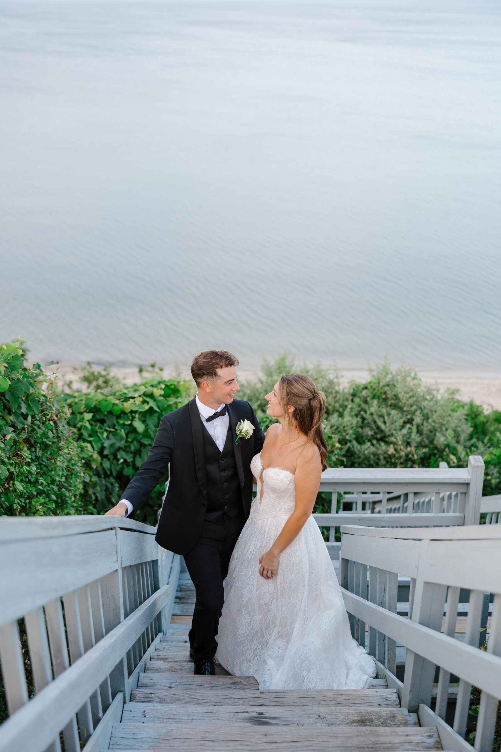 bride and groom portrait on white cliff looking over cape cod bay