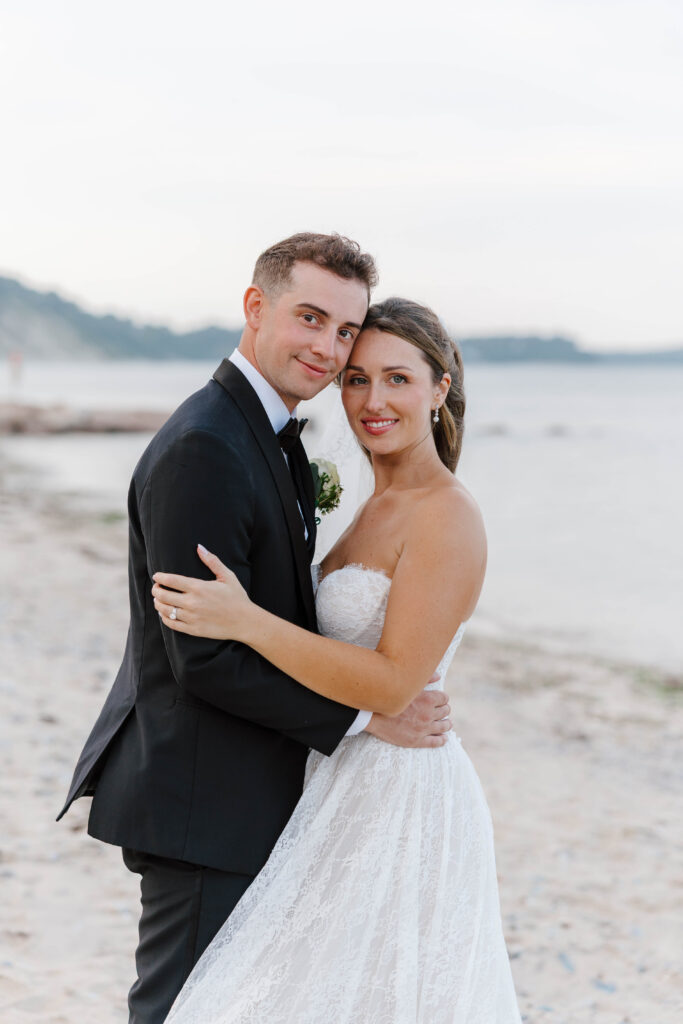 bride and groom portrait smiling at camera on the beach in plymouth, massachusetts