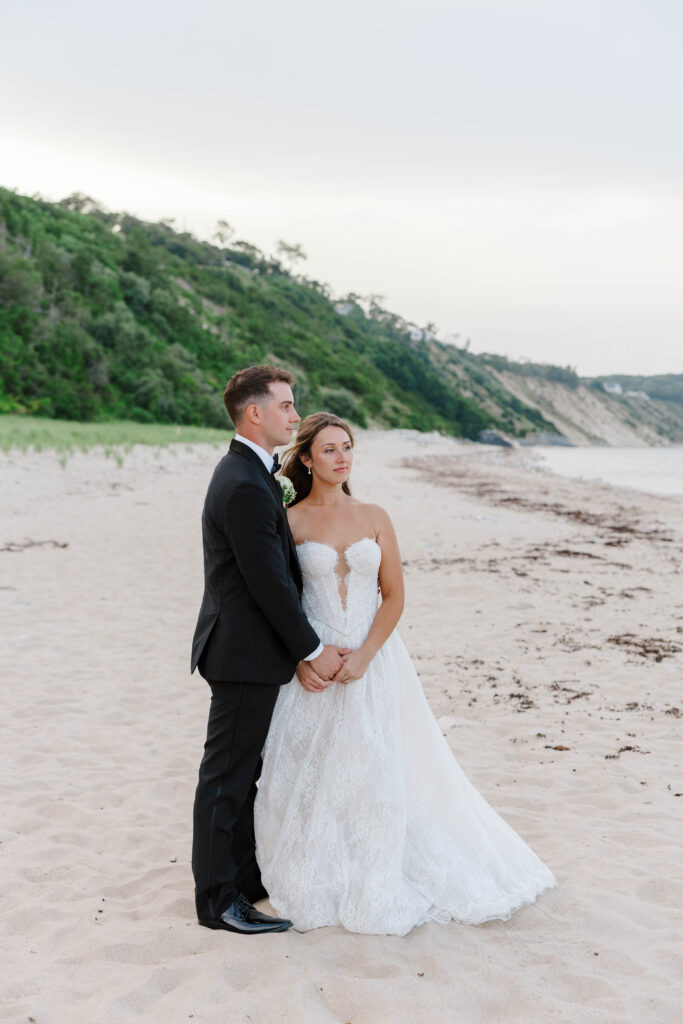bride and groom stare off to ocean at the white cliffs country club on cape cod
