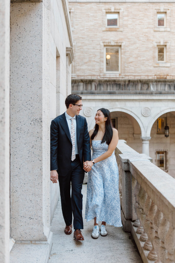 Man and woman walk on balcony at the Boston Public Library