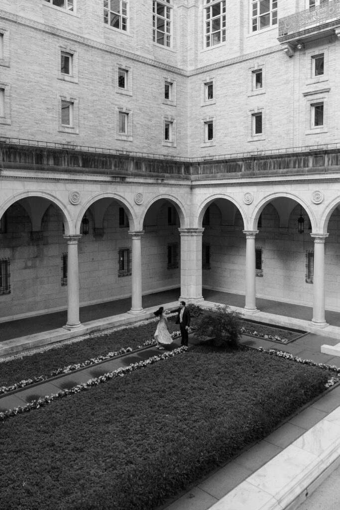 Man and woman walk in the courtyard of the Boston Public Library