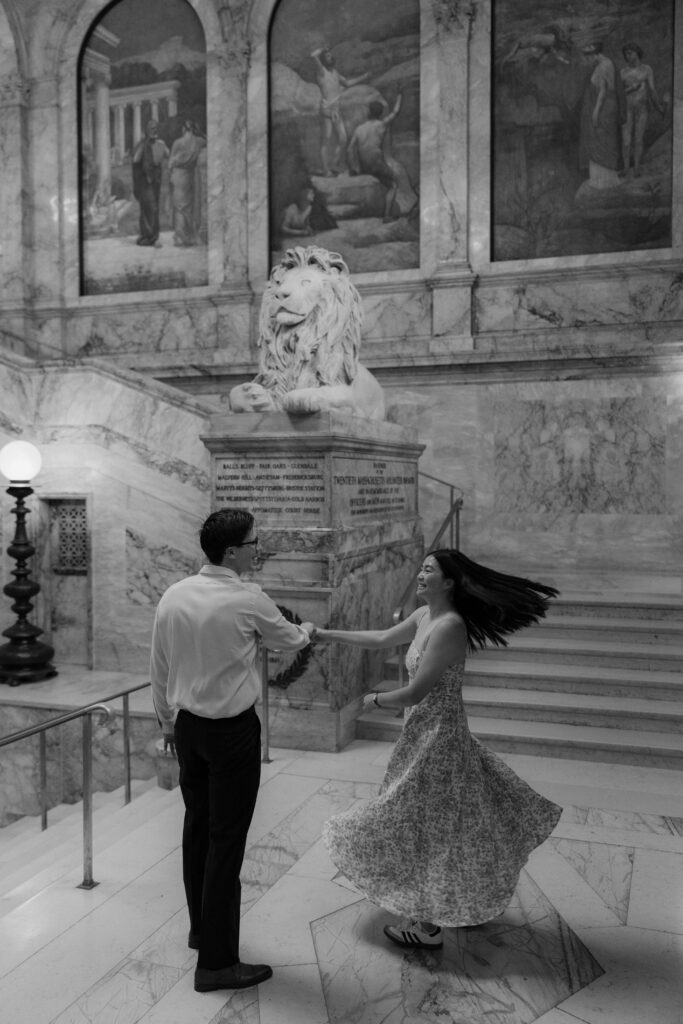 Man spins woman in black and white photo in the Boston Public Library