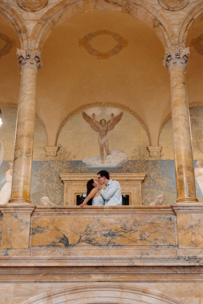 Man and woman kiss inside the Boston Public Library