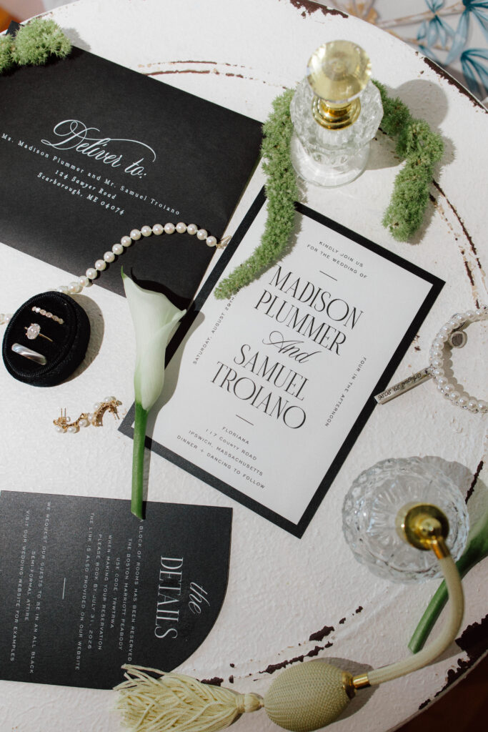 Flat lay details of wedding invitation with jewelry and other details