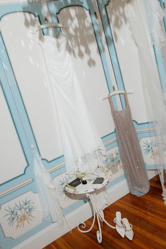 Editorial photo of wedding dresses hung on blue wardrobe