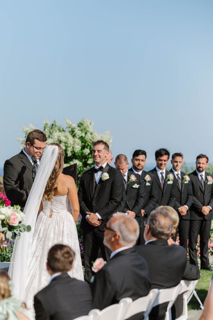 groom looks at bride during wedding ceremony at the white cliffs country club