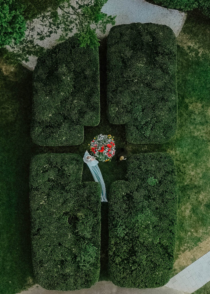 Drone photo of bride and groom walking in hedges on wedding day