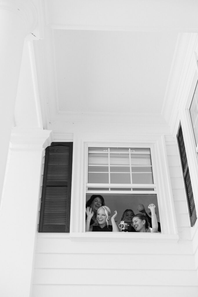 Bridal party celebrates couple outside window