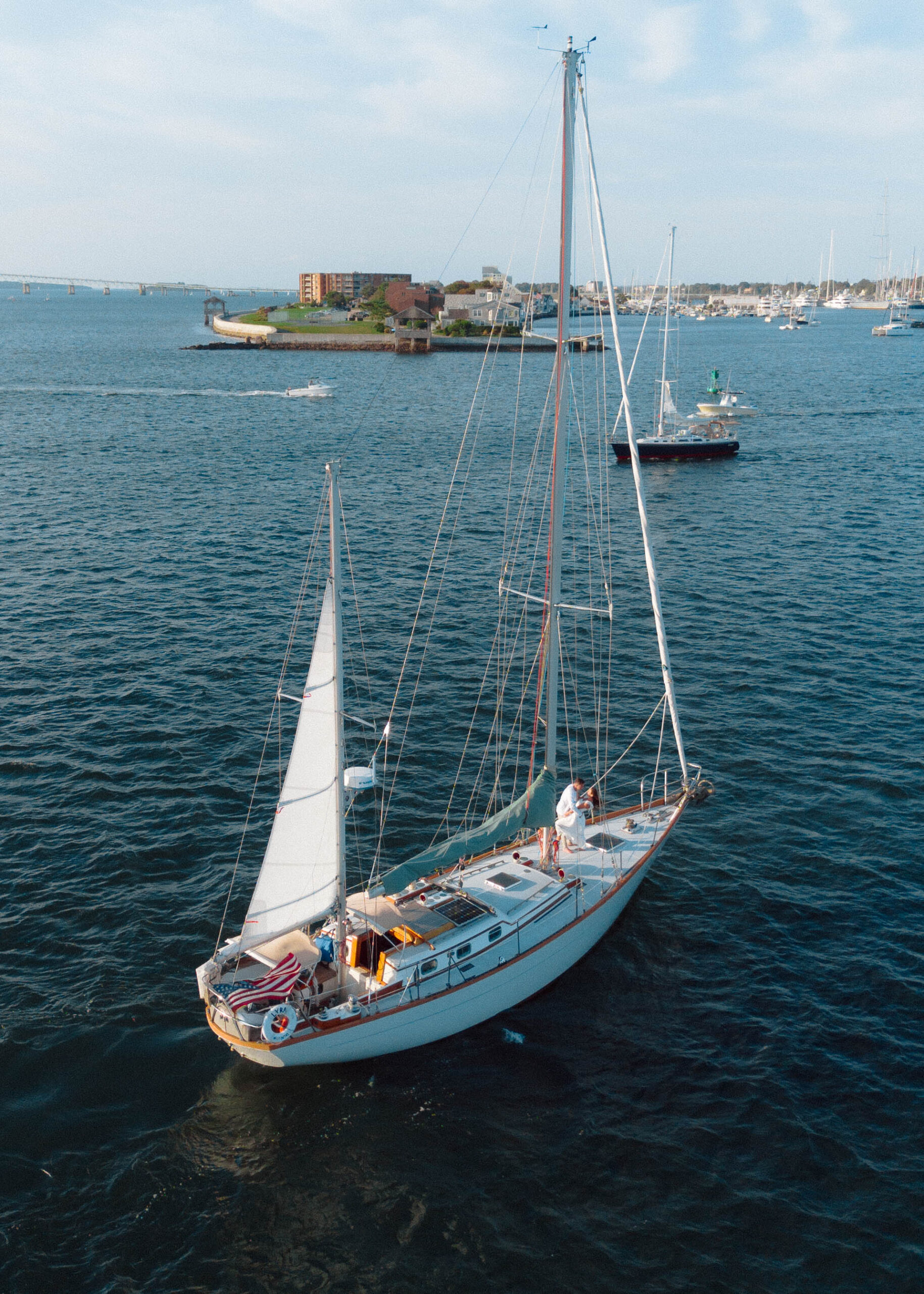 Aerial photo of sailboat with couple dipping on boat in Newport, Rhode Island